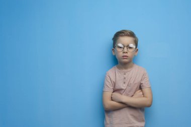 Gözlüklü, sevimli, ciddi bir çocuk.