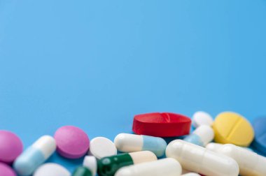 Düz konum - mavi arka planda çok renkli haplar, uyuşturucular ve kapsüller