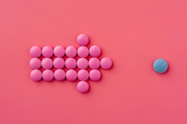 Pembe hapların yakın çekimi pembe bir yüzeye uzanıyor.