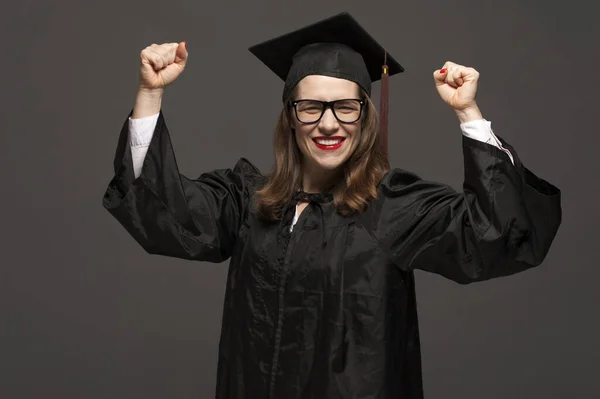 Portrait of graduate adult female student in black graduation gown — Stock Photo, Image