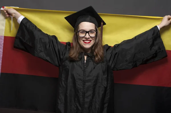 Urocza studentka uśmiechnięta w okularach w czarnym płaszczu — Zdjęcie stockowe