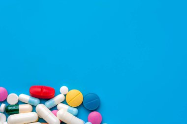 Düz konum - mavi arka planda çok renkli haplar, uyuşturucular ve kapsüller