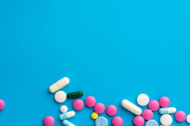 Düz konum - mavi arka planda çok renkli haplar, uyuşturucular ve kapsüller