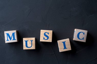 Tahta küplerin üzerinde karanlık masa üzerinde kelime MÜZİK.