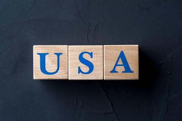 Holzwürfel mit Wort USA auf dunklem Tisch. Stockbild