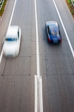 Beyaz araba ve geçen siyah arabaya