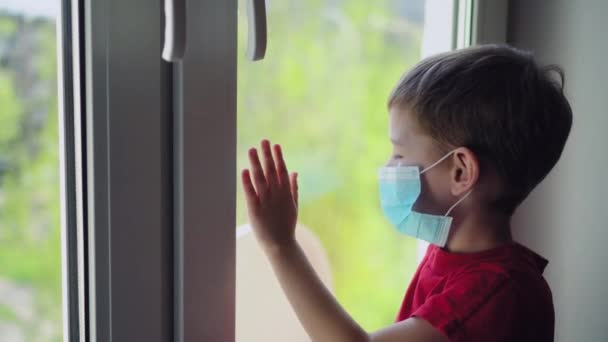 Niño Triste Máscara Medicina Sentado Cerca Ventana Mirando Hacia Fuera — Vídeos de Stock