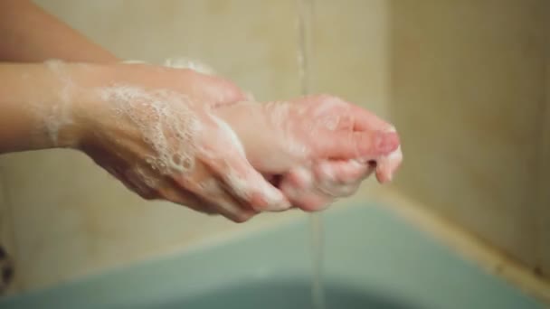 Frau wäscht sich im Badezimmer die Hände mit Seife