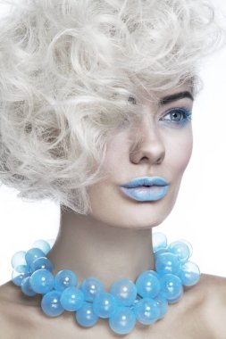 Genç güzel sarışın kadın şık mavi makyaj ve süslü cam kolye ile yakın çekim göz alıcı portresi 