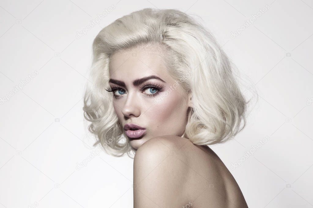 Vintage style portrait of young beautiful woman with platinum blonde hair and fresh make-up 