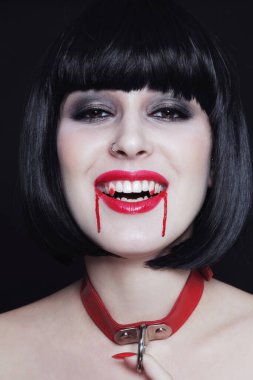 Vampir dişleri ve kanlarıyla genç ve güzel gotik bir esmer.