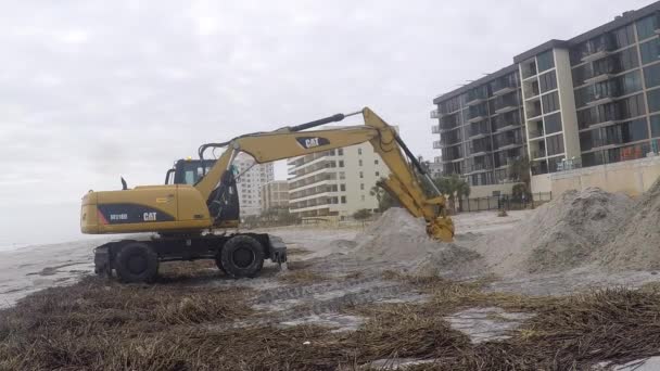 Un trattore Caterpillar che muove sabbia su una spiaggia dopo un uragano — Video Stock