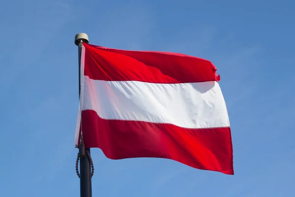 바람이 푸른 하늘에 대 한 오스트리아의 국기 — 스톡 사진