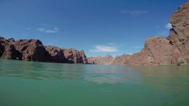 Boat drifting in sea with rocky mountains — Stockvideo