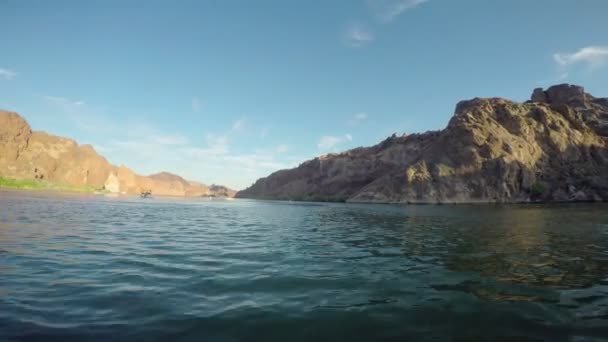 Bateau dérivant dans la mer avec des montagnes rocheuses — Video