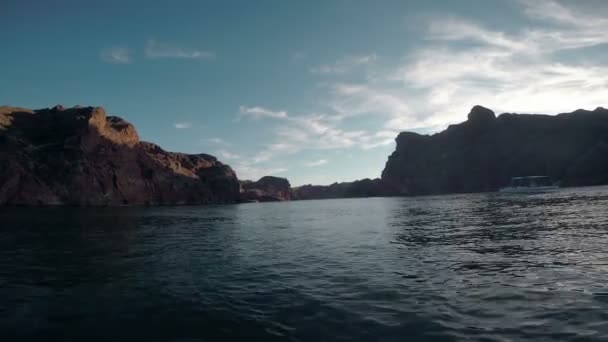 Boot treibt im Meer mit felsigen Bergen — Stockvideo