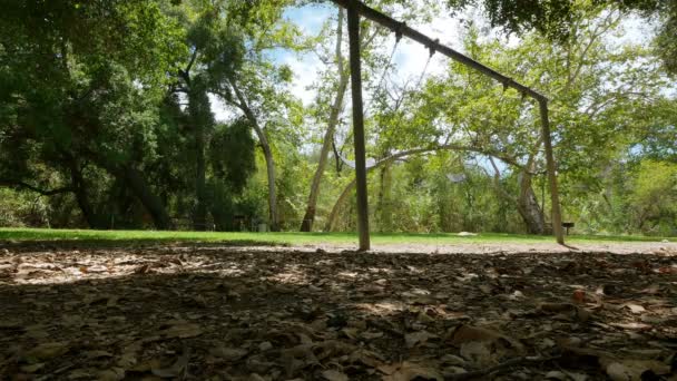 Пустельний Swingset в парку, швидко розвивається — стокове відео