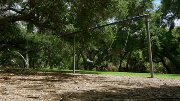 Vista de ângulo baixo de Swingset deserta no parque — Vídeo de Stock