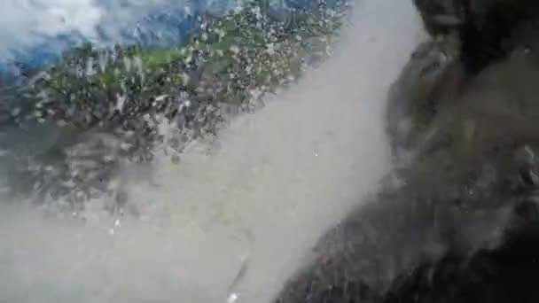 Висячие на скалах под водопадом — стоковое видео