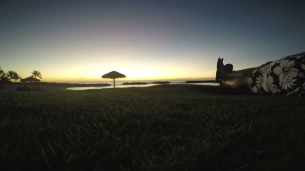Человек упал, наблюдая за закатом на Гавайях — стоковое видео