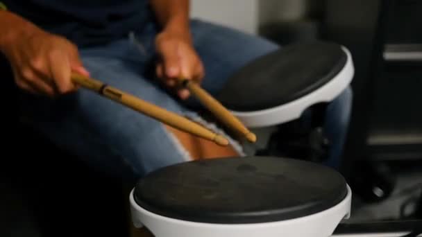 Молодой мужчина практикуется на барабанах — стоковое видео