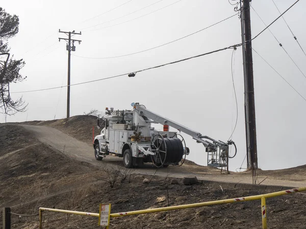 white commercial truck parked on road near damaged telephone line