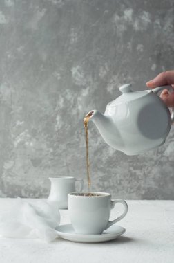 Beyaz fincan çay ve çaydanlık