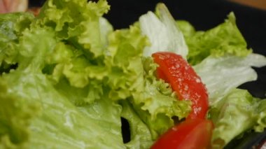 Taze salata ye, çatalla bir dilim domates al. Sağlıklı yemek.