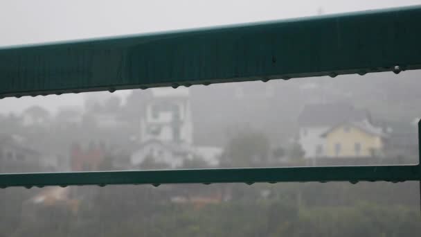 Gotas de agua goteando de la barandilla en el balcón durante las fuertes lluvias. Concepto de melancolía — Vídeos de Stock