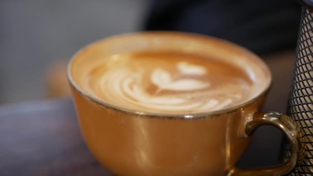Egy csésze kávé tejeskávéval. Barista gyönyörű műalkotást készített a tejhabból. Közelkép — Stock videók
