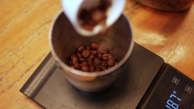 Barista uçakları adım adım uçuruyor. Barista kahve yapmak için kahve çekirdeklerini tartıyor. Kafede profesyonel alternatif kahve imalatı