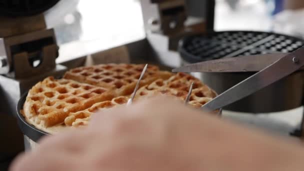 As mãos de Chefs tomam waffles belgas marrons de ouro de um ferro de waffle. Chef passo a passo preparar waffles belgas com bananas, morangos, sorvete, mel e xarope de chocolate — Vídeo de Stock