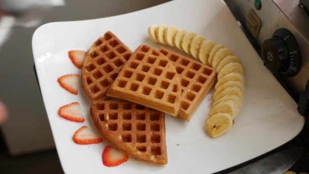 Chef bereitet nach und nach belgische Waffeln mit Bananen, Erdbeeren, Eis, Honig und Schokoladensirup zu — Stockvideo