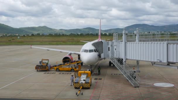 Embarque de aviones y carga de contenedores de carga. DALAT, VIETNAM - 01 DE DICIEMBRE DE 2019: Avión en preparación para el vuelo. Embarque con puente aéreo y carga — Vídeos de Stock