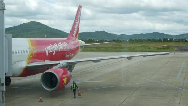 VietJet Air embarque y carga de contenedores de carga. DALAT, VIETNAM - 01 DE DICIEMBRE DE 2019: Avión en preparación para el vuelo. Embarque con puente aéreo y carga — Vídeo de stock