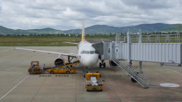 航空機の搭乗と貨物コンテナのロード。ダラット,ベトナム- 2019年12月1日:飛行機が飛行の準備をしています。航空橋での搭乗及び積込み — ストック動画