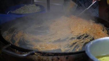 Cooking authentic traditional thai dish pad thai at asian night market. Cuisine of thailand. Asian Street food. Fried rice noodles popular dish in Asia
