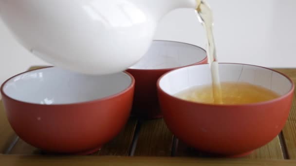 El maestro del té vierte té verde fermentado en tazas de té. Elemento de la cultura tradicional china. Primer plano. — Vídeos de Stock