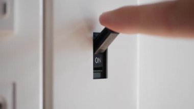 Işık kapalı. Erkek eli elektrik şalterini kapatır. 4k