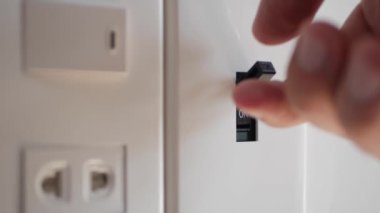 Işık kapalı. Erkek eli elektrik şalterini kapatır. 4k