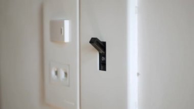 Işık kapalı. Erkek eli elektrik şalterini kapatır. 4k