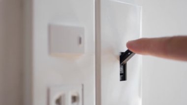 Işık kapalı. Erkek eli elektrik şalterini kapatır. 4k