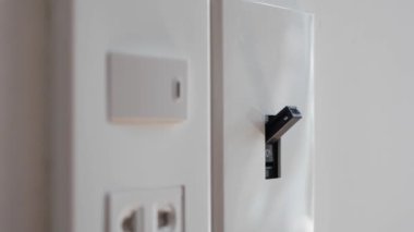 Işık kapalı. Erkek eli elektrik şalterini kapatır. 4k