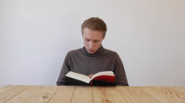 Kitap okuyan genç yakışıklı bir adam. Öğrenci. Bilgi kavramı