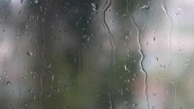 Şiddetli yağmur suyu pencere camlarına ve akıntıya karşı akar. Yakın plan. Yağmur mevsiminde cam zemin üzerinde yağmur damlaları. 4k