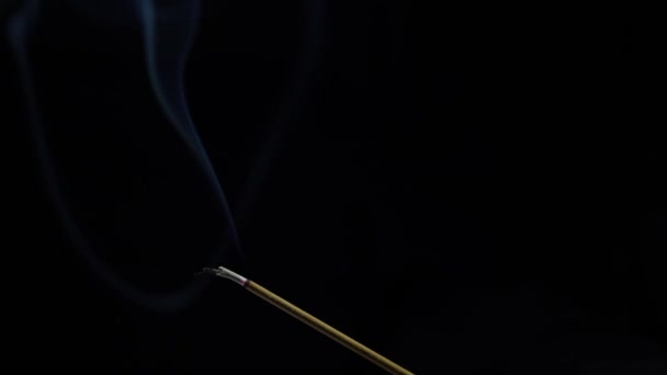 焼香棒のクローズアップビュー。煙は熱いメンバーの端から吹く。黒を基調に香から解放された香り。リラクゼーション,瞑想とアロマセラピー.4k — ストック動画