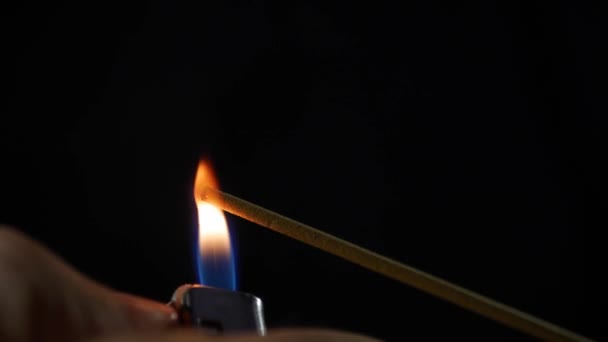 Vue rapprochée du bâton d'encens brûlant. La fumée souffle de la fin du mois de décembre chaud. Parfum libéré de l'encens sur fond noir. Détente, méditation et aromathérapie. 4k 