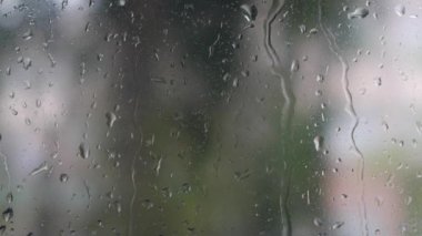 Şiddetli yağmur suyu pencere camlarına ve akıntıya karşı akar. Yakın plan. Yağmur mevsiminde cam zemin üzerinde yağmur damlaları. 4k