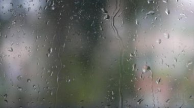 Şiddetli yağmur suyu pencere camlarına ve akıntıya karşı akar. Yakın plan. Yağmur mevsiminde cam zemin üzerinde yağmur damlaları