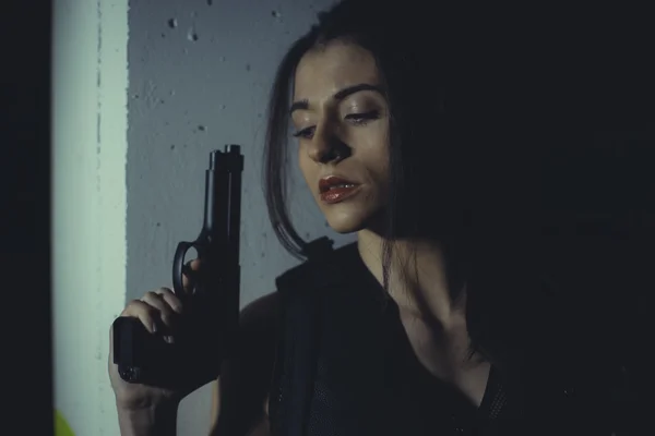 Girl posing with handgun and bulletproof vest — Stock Photo, Image